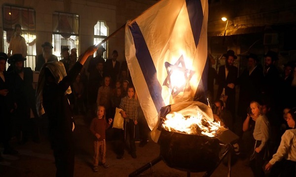 گروهی از یهودیان در قدس اشغالی پرچم رژیم صهیونیستی را آتش زدند